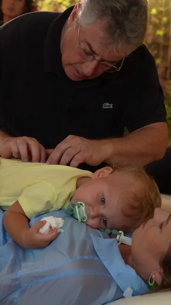 Home Dr. Mark Dulberg adjusting an infant resting on a treatment table at Luxury Chiropractic